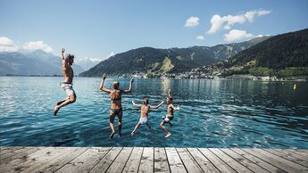 Familie springt voller Freude in den Zeller See | © Zell am See-Kaprun Tourismus